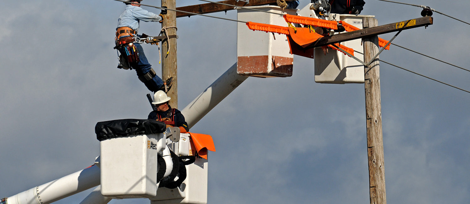 Electric linemen working in lifts on wires above